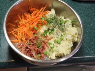 7、土豆方块,将土豆泥、红萝卜、培根放入盆内，加入切碎的香菜。