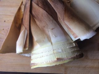 2、油焖春笋,看似非常大的笋，用刀破开扒去笋衣。切除边缘一些粗糙的地方