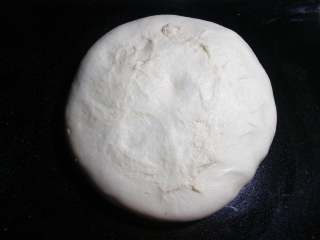 5、肉松面包卷,将发酵好的面团倒出，轻拍排气 。