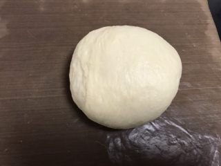 4、肉松奶酪面包卷,取出排气，排气会后盖保鲜膜松弛15分钟