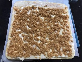 12、肉松奶酪面包卷,出炉放网架稍微放凉，均匀的摸上搅拌好的奶油奶酪，撒上肉松，卷起，放至半个小时定型