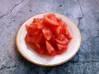 3、番茄鸡蛋青豆,将西红柿切成块。