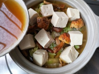13、白菜豆腐煲,将炒过的白菜移入砂锅中，将焯过水的豆腐滑入砂锅，加入泡发菌菇的水。加盖炖煮。
