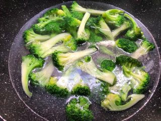 4、杏鲍菇炒西兰花,锅里放入一大碗水烧开，放入一勺盐，一勺油，少许白糖调匀，把洗好西兰花放入焯30秒，焯好捞起来用冷水冲凉待用。