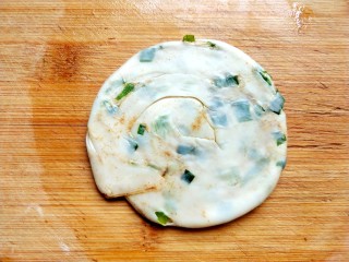 15、饺子皮葱油饼,再用擀面杖擀成圆饼。
