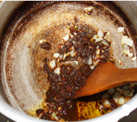 8、酱炖芸豆,高压锅放入火上，放入适量油，待油温高后放入洋葱、蒜粒翻炒，放入酱翻炒；