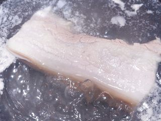 6、川味回锅肉,五花肉洗净,烧半锅水,先把五花肉焯水,去掉浮末和杂质;