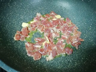 7、牛肉小炒,炒锅内倒适量的食用油烧热，下入腌好的牛肉片。