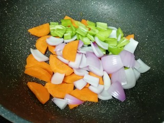 9、牛肉小炒,锅底留余油，下入胡萝卜洋葱青椒片翻炒均匀。