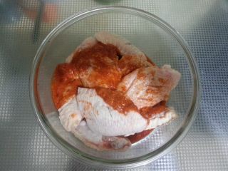 5、最受欢迎的烤箱菜【新奥尔良风味烤翅】,将鸡翅放入保鲜盒内，倒入调好的腌料，充分搅拌均匀。