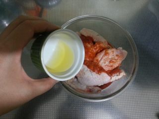 6、最受欢迎的烤箱菜【新奥尔良风味烤翅】,将色拉油倒入容器里搅拌均匀。