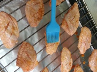 9、最受欢迎的烤箱菜【新奥尔良风味烤翅】,将鸡翅均匀的放到烤网上，腌鸡翅的容器中会有剩余的腌料，用油刷在鸡翅表面刷一层腌料。