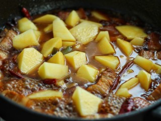 12、红烧肉炖土豆,待红烧肉八分熟时，放入土豆块继续炖煮20-30分钟(具体时间根据土豆块的大小而定)