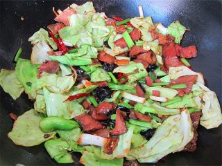 8、腊肉蒜香卷心菜,倒入包菜快速翻炒一分钟