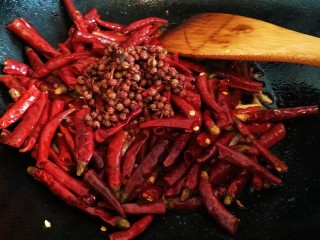 17、椒香辣子鸡,倒入干辣椒段和花椒，翻炒一分钟，使其充分出味。