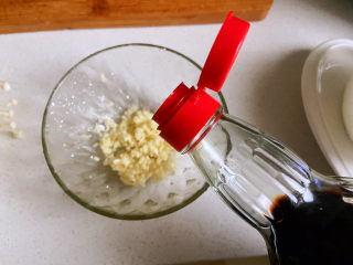 6、豆皮金针菇卷,把大蒜切成末,倒入生抽。