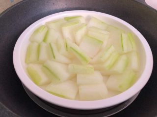 4、肉末冬瓜,冬瓜去皮去瓤,清洗干净切成片,摆入盘里,蒸锅放入适量水烧开,把冬瓜放入蒸10分钟取出待用。