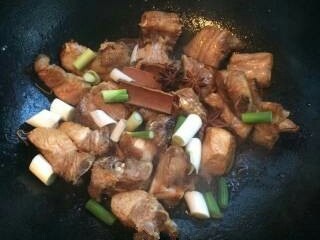 6、红烧排骨,加入大葱段，八角桂皮继续翻炒。