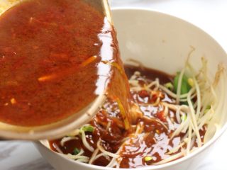 10、麻辣水煮鱼,捞出鱼骨、鱼头，将红汤倒入码着蔬菜的大碗中。