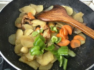 14、闷汁土豆片,加入胡萝卜和青椒继续翻炒一分钟