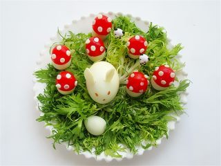 12、趣味吃蛋法,洗净的苦菊铺好在盘子中，将做好的小蘑菇和小兔子都摆放上去，一盘就做好啦