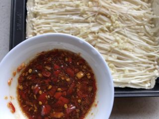 4、蒜香金针菇,将色拉油，蚝油、生抽，辣椒调成汁水、尝一下咸淡