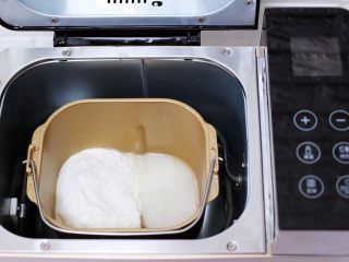 2、百吃不厌的韭菜盒子,称重后的中筋面粉和清水倒入面包机里，加入2克盐后，启动面包机的和面程序。