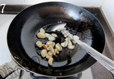 7、蒜香排骨,起炒锅,热锅凉油下入蒜瓣,小火慢慢煸炒至蒜瓣表面金黄色,盛出蒜瓣备用;