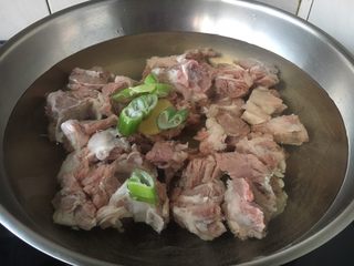 8、番茄土豆烧牛肉,放入2勺的黄酒和少许的姜片、葱段。