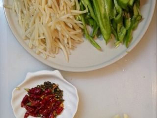 2、青椒土豆丝,改刀切丝,干红辣椒剪成段,大蒜切片