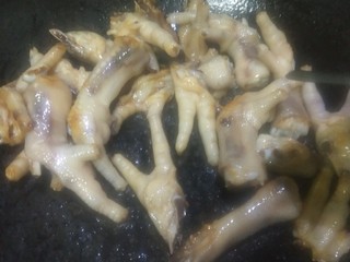 6、红烧鸡爪,放入控水后的鸡爪，炒至两面金黄