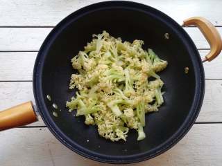 6、干煸花菜,锅加油烧热,下入花菜大火炒去水分,再用中小火炒至断生