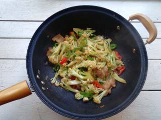 13、干煸花菜,加入盐,料酒,生抽酱油和老抽酱油,快速翻炒均匀即可,盛出装盘