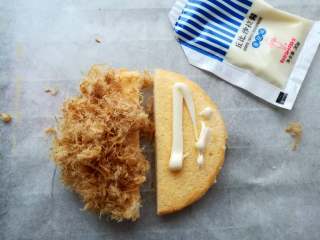 16、肉松小贝,在蛋糕的底部涂上适量的沙拉酱,一边放上肉松