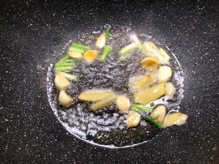 8、水煮肉片,热锅放入适量油，放入蒜瓣，葱白，姜片炒香。