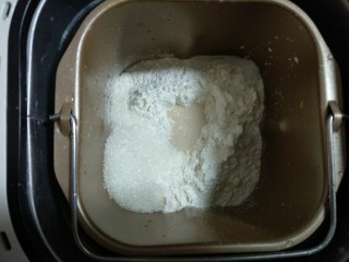 1、芝士汉堡,把除黄油的面团材料放入面包桶，糖和盐对角放，中间挖个坑放入酵母，启动面包机揉面。