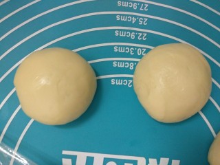 4、芝士汉堡,排气后将面团分成50克一个搓圆，盖上保鲜膜静置10分钟。