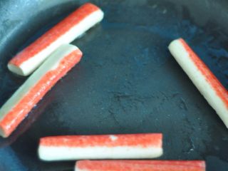 2、韩式紫菜包饭便当,蟹棒下锅煎至两面金黄。