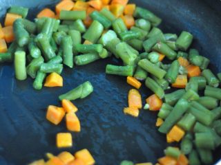 9、韩式紫菜包饭便当,将熟豆角切丁，下锅后放入盐和蚝油即可出锅。