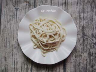 5、蒜蓉芝麻酱拌面,松弛到位的面团非常有弹性和柔韧度，按这样的切法先拿一块面片切成条状，其余面片继续用保鲜膜盖好，防止干掉。切好的细长条，用手拿起一条拽住两端，匀力先慢慢往两边拉长，拉出合适的粗细即可。