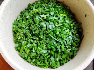 3、不擀皮～皮薄馅大～韭菜馅饼,韭菜洗干净控水之后切成末，放入大碗里。