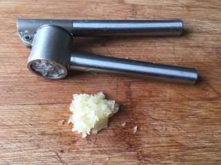 3、水煮肉片,用压蒜器将蒜瓣压成蒜泥，没有压蒜器就用刀剁成末；