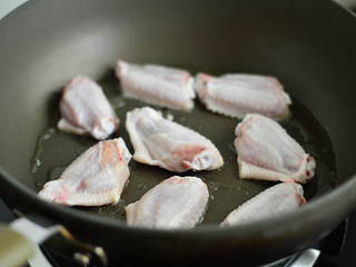 2、啤酒鸡翅,锅里倒入少许油，将鸡翅皮那面朝下放入煎制