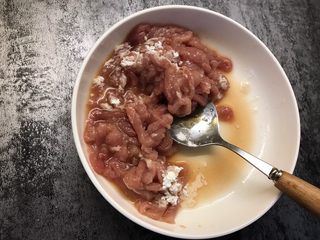 5、鱼香肉丝,再加入一勺淀粉和一勺油搅拌均匀