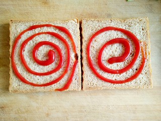 6、沼三明治,在吐司片上涂抹适量的番茄酱。