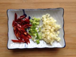 6、蓑衣黄瓜,在腌制黄瓜期间，把蒜瓣切小粒，香葱切成葱花，辣椒去籽，剪成小条