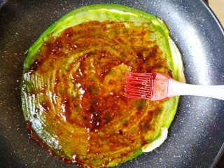 13、菠菜煎饼果子,在面饼上刷上蒜蓉辣酱和照烧酱。经典的做法是放甜面酱。