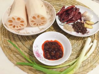 1、麻辣藕片,备好材料，莲藕可以买一整根，也可以买清理好的两节，干红辣椒15根，郫县豆瓣酱1勺，这个辣度是微辣，可以根据个人口味酌量增减，小葱2根，姜2片，蒜2瓣，花椒1小把，白芝麻少许