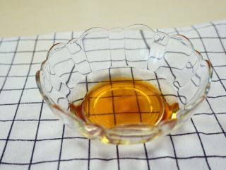 11、蜜汁烤排骨,取一只空碗,里面放适量油和蜂蜜。