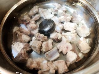 5、排骨炖萝卜,锅中重新倒入适量清水放入排骨和调料盒再放入料酒和糖大火炖20分钟再中火炖30分钟